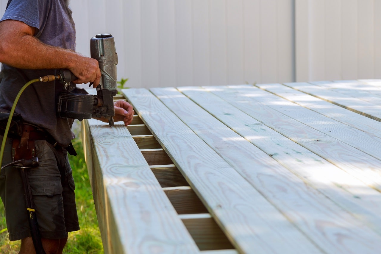 contractor bolting down deck boards.
