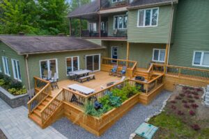 aerial view of a large wooden deck connected to a green hosue.