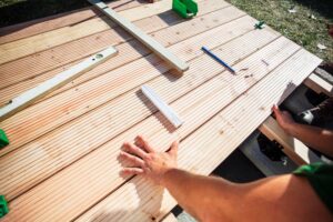 View of a man measuring deck boards.