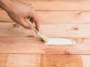 Stock image of a hand painting a wood deck.