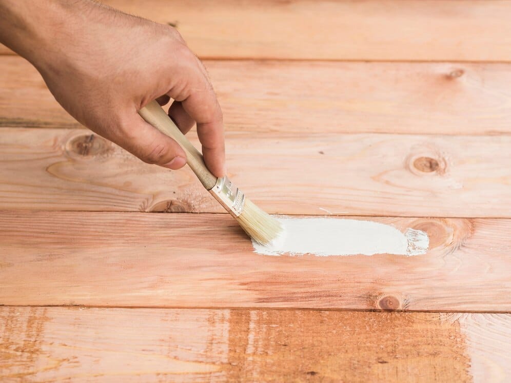 Stock image of a hand painting a wood deck.