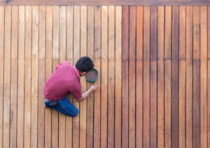 Contractor staining an outdoor deck